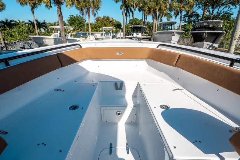 Slide: The Image of 2025 Sea Hunt Ultra 255 SE boat interior with brown seating and white deck. - 36