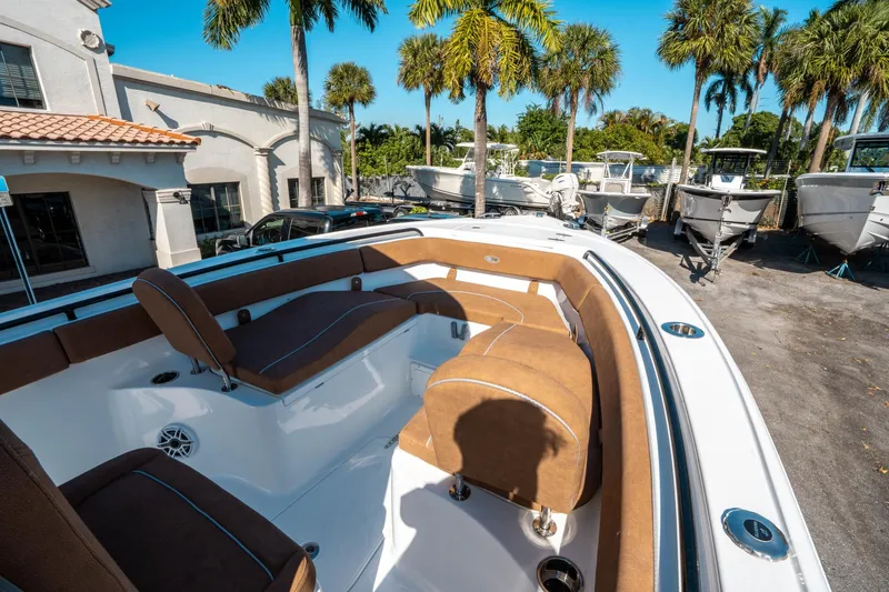 Slide: The Image of 2025 Sea Hunt Ultra 255 SE boat with brown seating, parked near palm trees. - 33