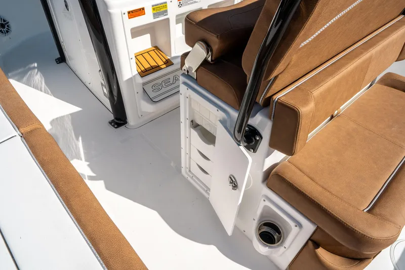Slide: The Image of 2025 Sea Hunt Ultra 255 SE boat interior with brown seating and storage compartment. - 18