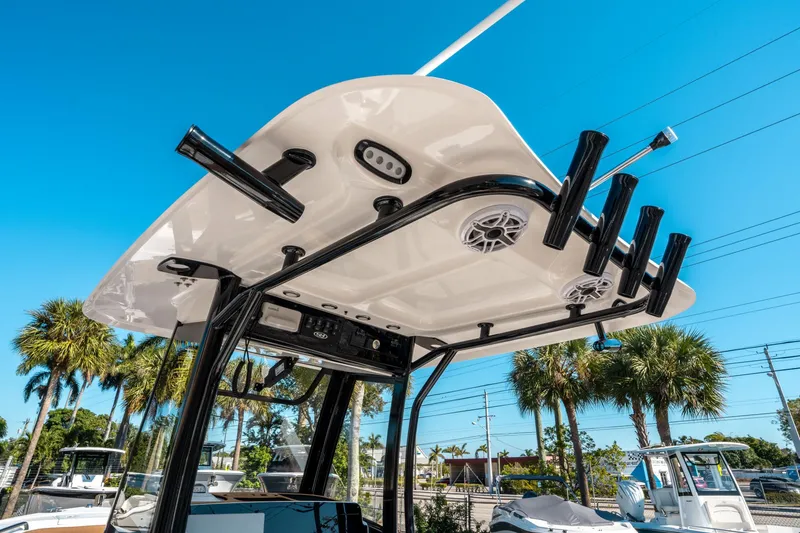 Slide: The Image of 2025 Sea Hunt Ultra 255 SE boat with rod holders and speakers under a clear blue sky. - 22