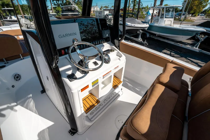 Slide: The Image of 2025 Sea Hunt Ultra 255 SE boat interior with Garmin navigation system and brown seating. - 24