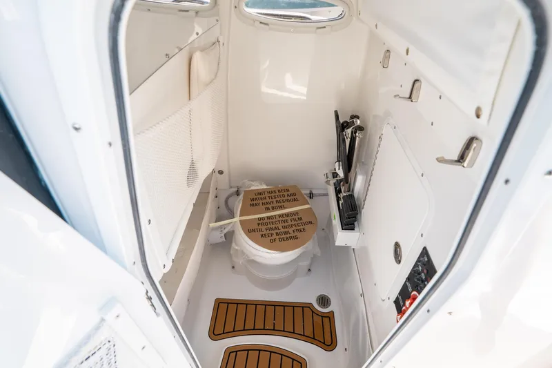Slide: The Image of 2025 Sea Hunt Ultra 255 SE boat interior with compact marine toilet. - 31