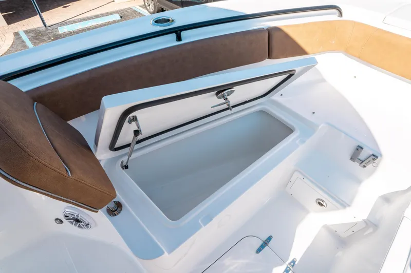 Slide: The Image of 2025 Sea Hunt Ultra 255 SE boat with open storage compartment and cushioned seating. - 38