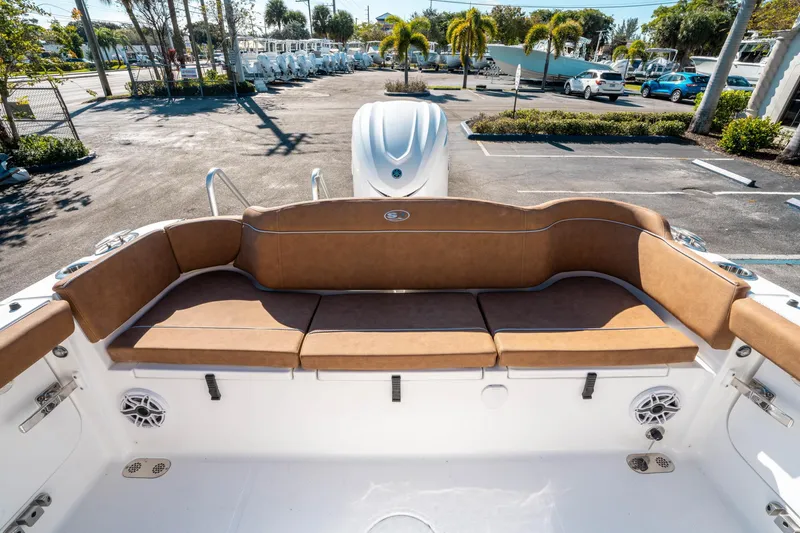 Slide: The Image of 2025 Sea Hunt Ultra 255 SE boat with tan seating in a sunny parking lot. - 10