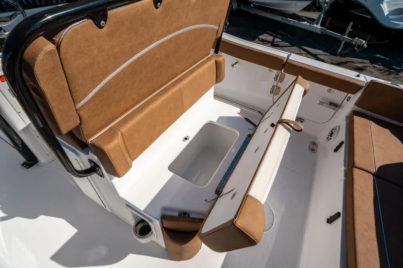 Slide: The Image of 2025 Sea Hunt Ultra 255 SE boat interior with brown seating and storage compartment. - 17