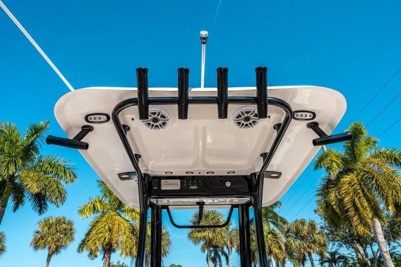 Slide: The Image of Sea Hunt Ultra 255 SE 2025 boat top view with rod holders and speakers, palm trees background. - 20