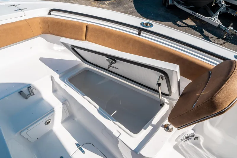 Slide: The Image of 2025 Sea Hunt Ultra 255 SE boat interior with open storage compartment and cushioned seating. - 39