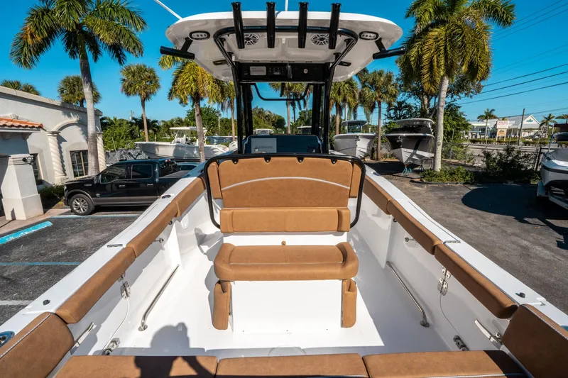 Slide: The Image of 2025 Sea Hunt Ultra 255 SE boat interior with tan seating, parked outdoors. - 9