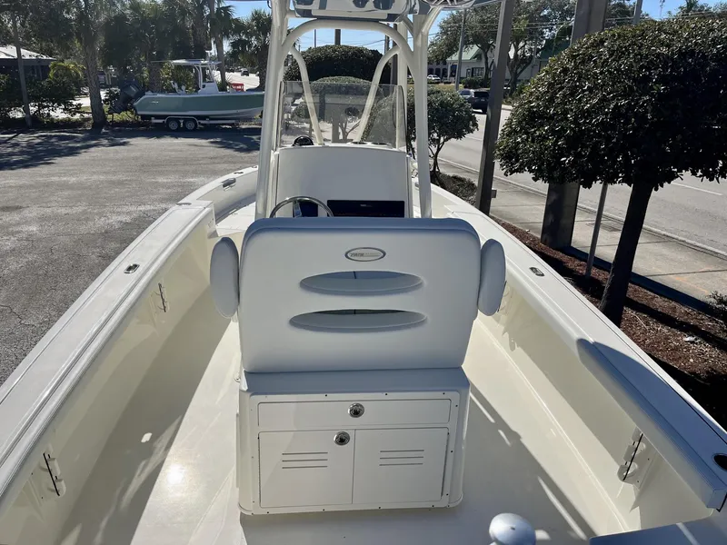 Slide: The Image of 2025 Pathfinder 2400 TRS boat interior with console and seating, parked outdoors. - 10