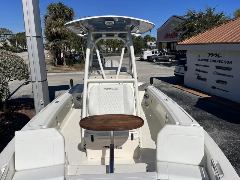 Slide: The Image of 2025 Pathfinder 2400 TRS boat with seating and table, parked at Marine Connection dealership. - 21