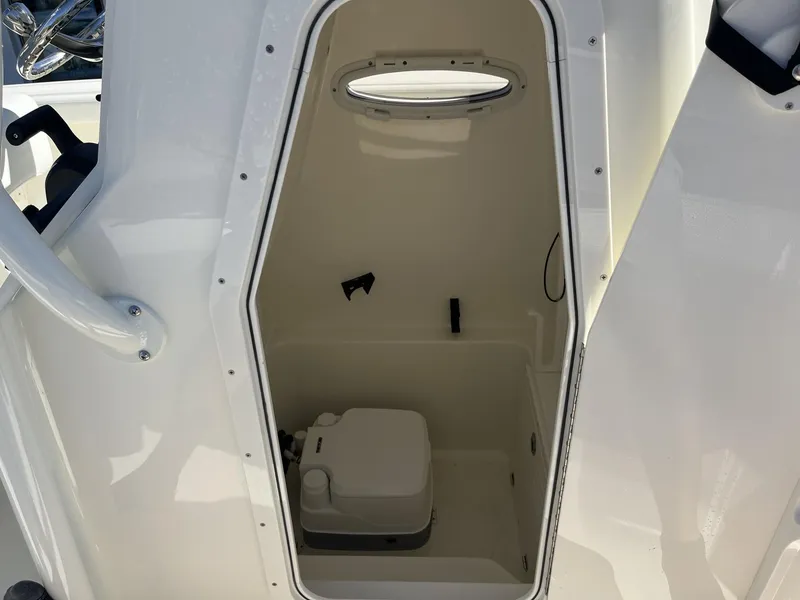 Slide: The Image of Interior view of 2025 Pathfinder 2400 TRS boat compartment with a small toilet. - 22