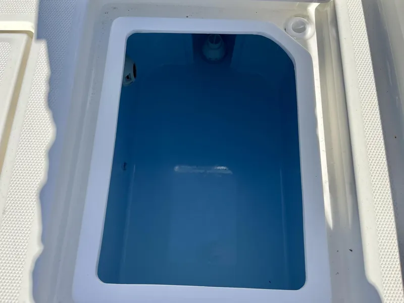 Slide: The Image of Livewell compartment on 2025 Pathfinder 2400 TRS boat, featuring a clean blue interior. - 26