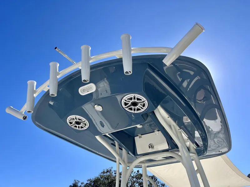 Slide: The Image of Pathfinder 2400 TRS 2025 boat T-top with rod holders and speakers against clear blue sky. - 33