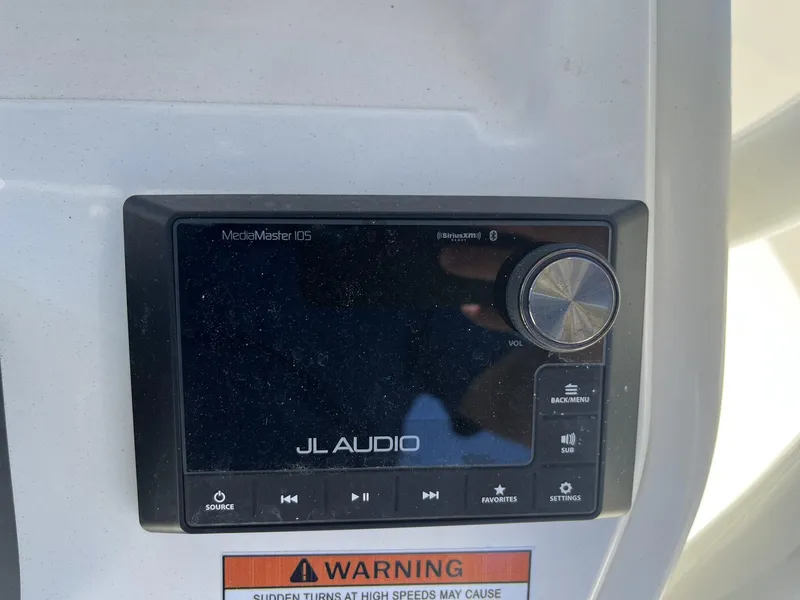Slide: The Image of JL Audio MediaMaster 105 control panel on 2025 Pathfinder 2400 TRS boat dashboard. - 12