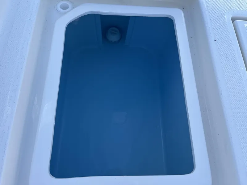Slide: The Image of Livewell compartment on 2025 Pathfinder 2400 TRS boat, featuring a clean, blue interior. - 27