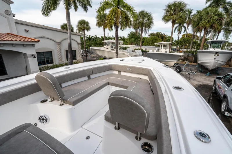 Slide: The Image of 2025 Sea Hunt Ultra 275 SE boat with spacious seating, parked near palm trees. - 33