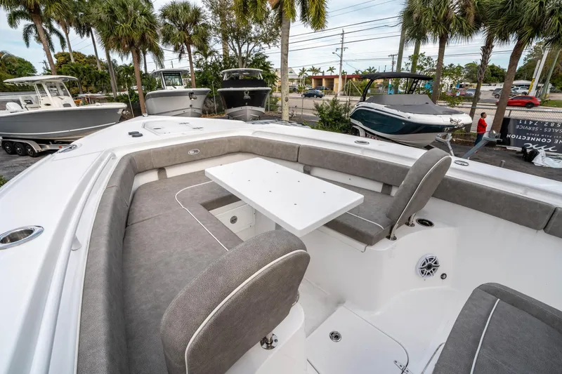 Slide: The Image of 2025 Sea Hunt Ultra 275 SE boat with spacious seating and table, surrounded by palm trees. - 37