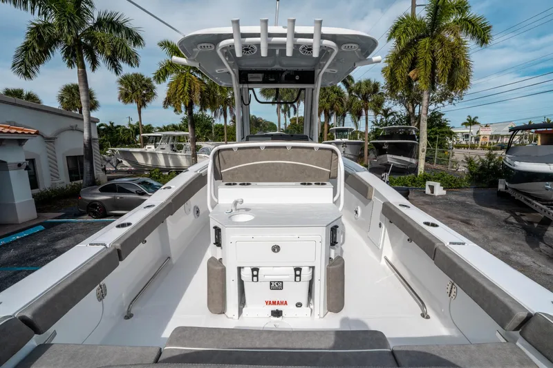 Slide: The Image of 2025 Sea Hunt Ultra 275 SE boat interior with seating and console, parked outdoors. - 9