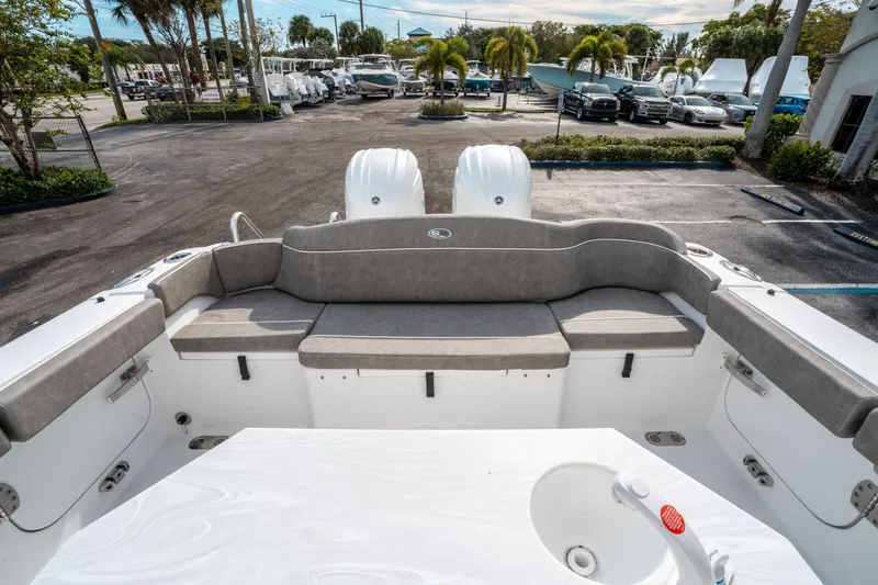 Slide: The Image of 2025 Sea Hunt Ultra 275 SE boat interior with seating and dual engines in a marina setting. - 10