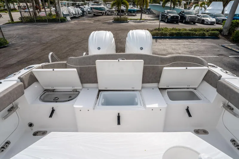 Slide: The Image of 2025 Sea Hunt Ultra 275 SE boat with open storage compartments and dual engines. - 14