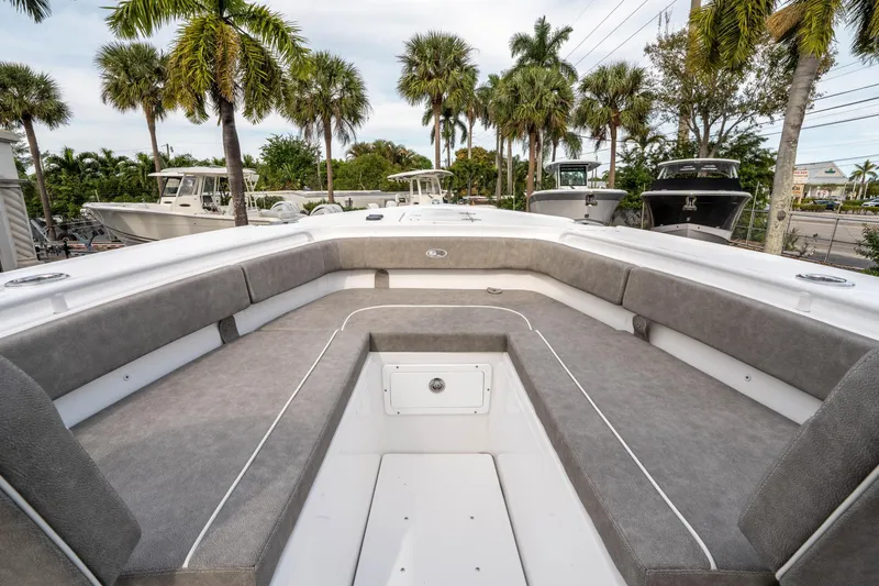 Slide: The Image of 2025 Sea Hunt Ultra 275 SE boat interior with cushioned seating and palm trees in the background. - 34