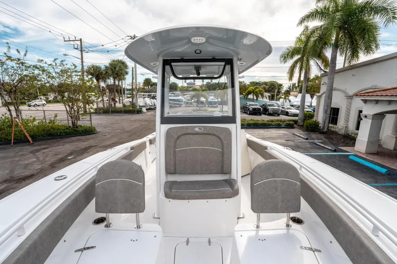 Slide: The Image of 2025 Sea Hunt Ultra 275 SE boat interior with seating, parked near palm trees. - 43