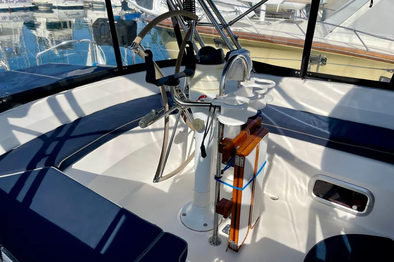 Slide: The Image of 1998 Hunter Passage 42 yacht cockpit with steering wheel and seating, docked at marina. - 21