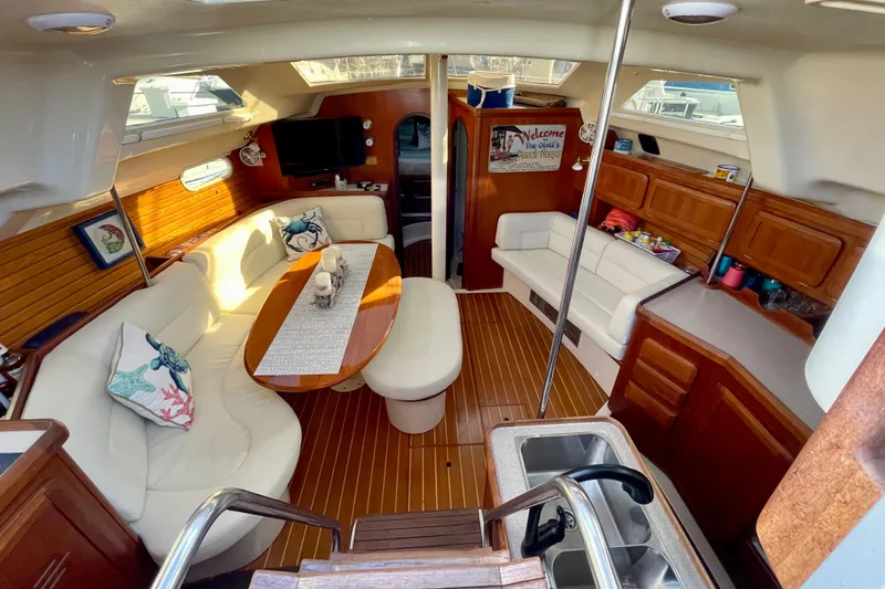 Slide: The Image of 1998 Hunter Passage 42 yacht interior with cozy seating, wooden flooring, and modern amenities. - 32