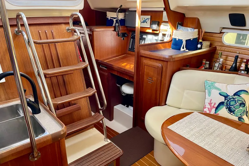 Slide: The Image of Interior of 1998 Hunter Passage 42 sailboat with wooden finishes and cozy seating area. - 44