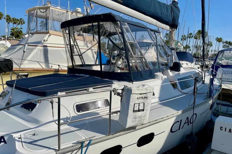 Slide: The Image of 1998 Hunter Passage 42 sailboat docked, featuring a sleek design and clear canopy. - 7