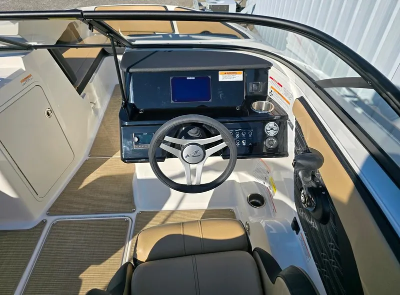 Slide: The Image of 2025 Sea Ray SPX 210 BR boat interior with steering wheel and dashboard controls. - 12