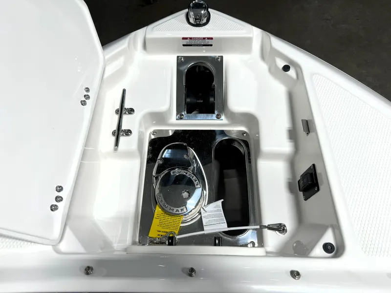 Slide: The Image of 2025 Chaparral 267 SSX boat anchor compartment with chrome fittings and storage spaces. - 11