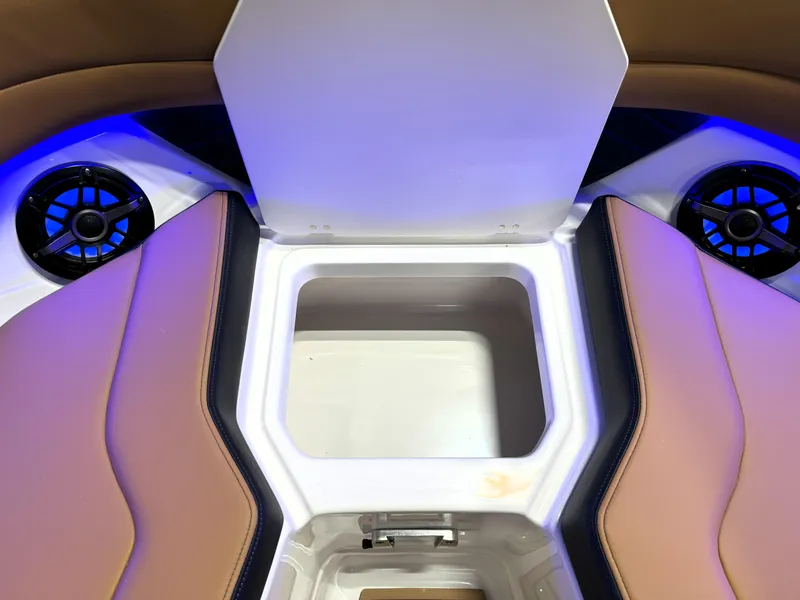 Slide: The Image of 2025 Chaparral 267 SSX boat interior with open storage compartment and speakers. - 13
