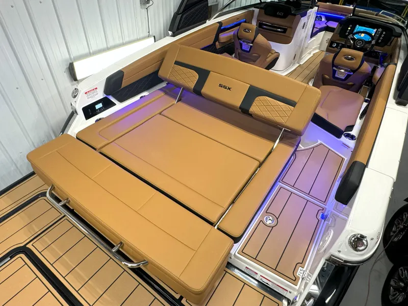 Slide: The Image of 2025 Chaparral 267 SSX boat interior with tan leather seating and modern dashboard. - 17