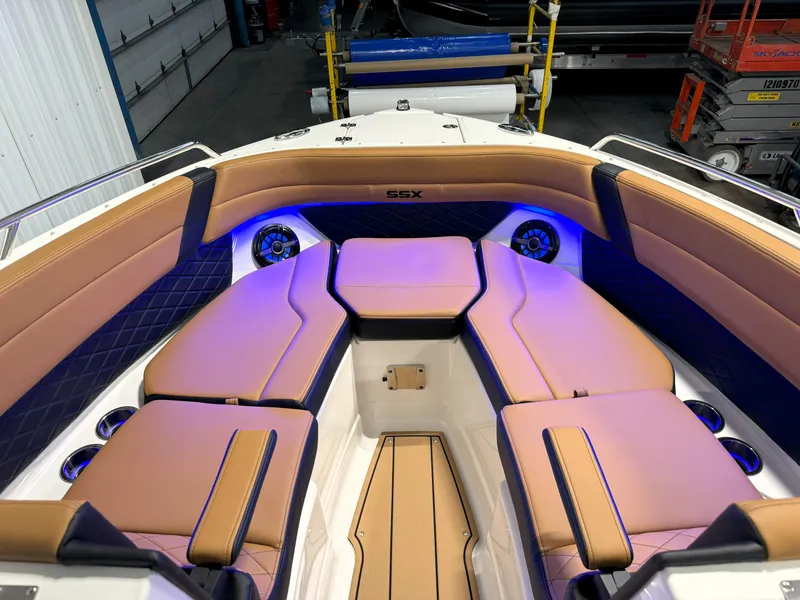 Slide: The Image of 2025 Chaparral 267 SSX boat interior with tan seating and blue LED lighting. - 20