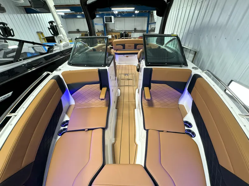 Slide: The Image of 2025 Chaparral 267 SSX boat interior with tan seating and ambient lighting. - 21