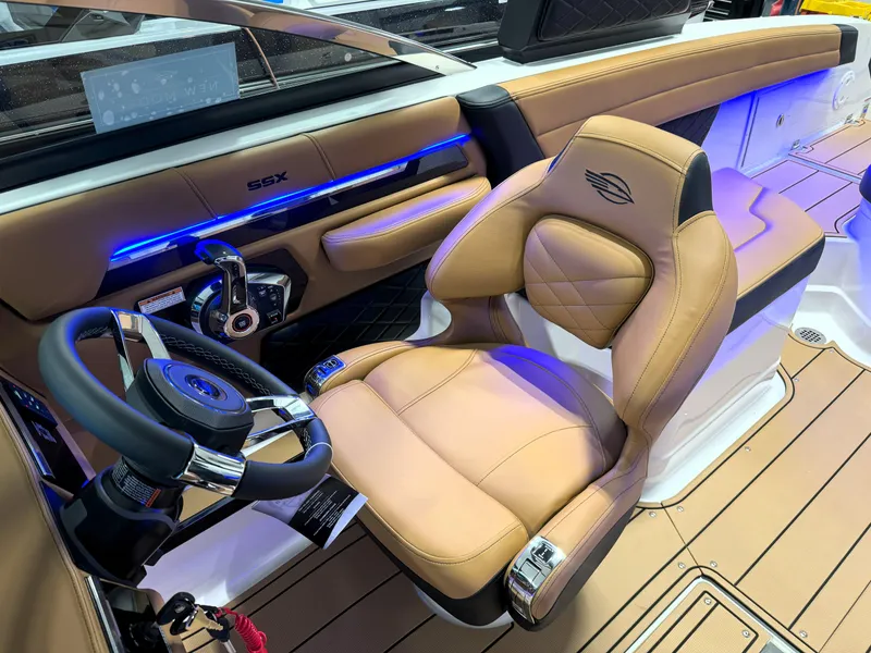 Slide: The Image of 2025 Chaparral 267 SSX boat interior with tan leather seating and modern dashboard. - 25