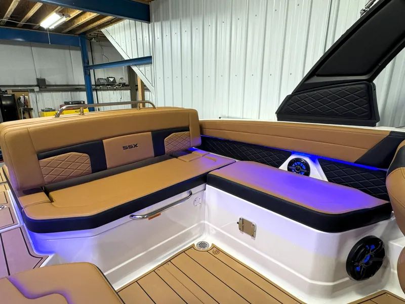Slide: The Image of 2025 Chaparral 267 SSX boat interior with tan seating and blue LED lighting. - 8