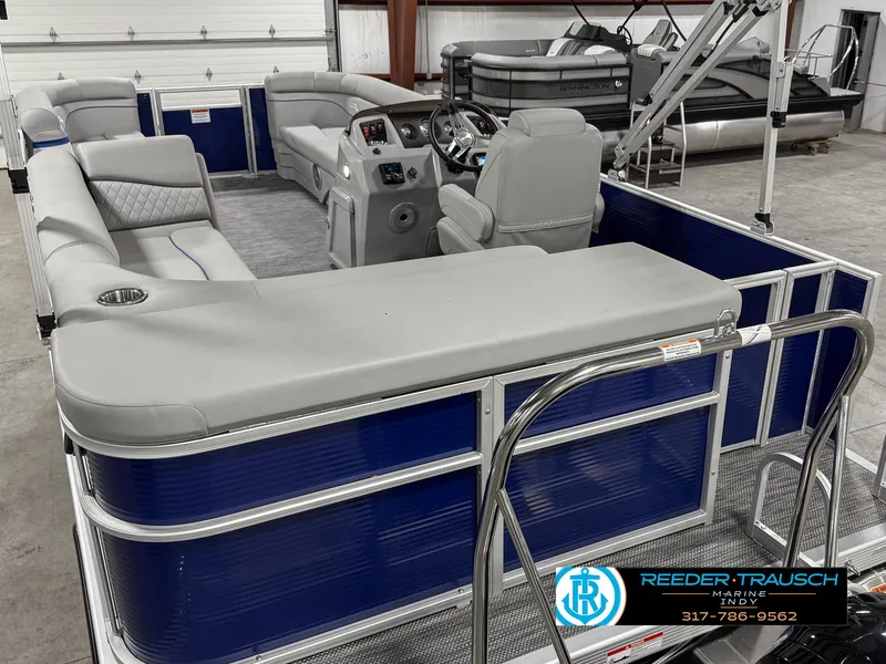 Slide: The Image of 2023 Bennington 208 SL pontoon boat with gray seating and blue exterior in a showroom. - 15