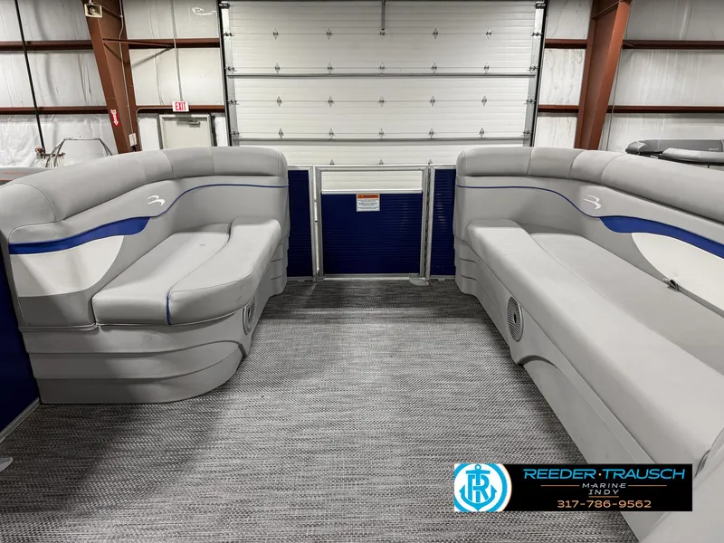 Slide: The Image of 2023 Bennington 208 SL pontoon boat interior with gray seating in a showroom. - 19