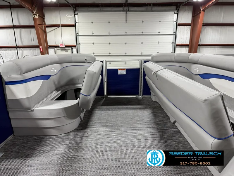 Slide: The Image of 2023 Bennington 208 SL boat interior with gray seating in a showroom. - 20