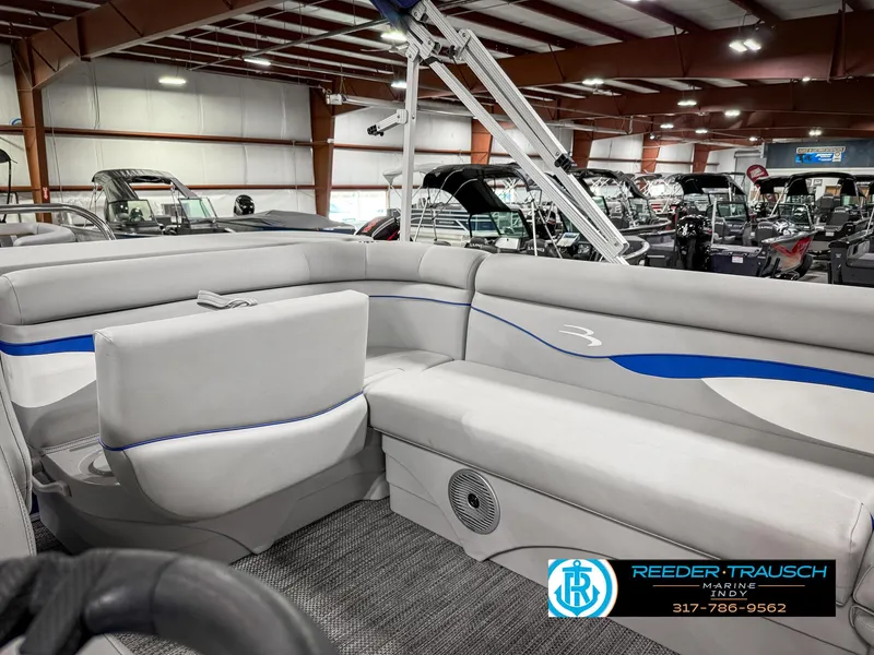 Slide: The Image of 2023 Bennington 208 SL pontoon boat interior with gray seating and blue accents. - 25