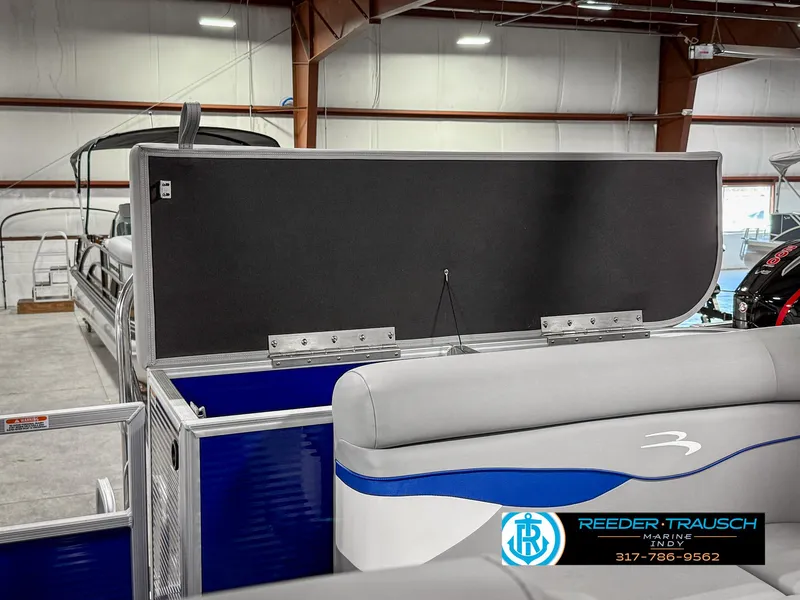 Slide: The Image of 2023 Bennington 208 SL pontoon boat interior with seating and storage, displayed indoors. - 27