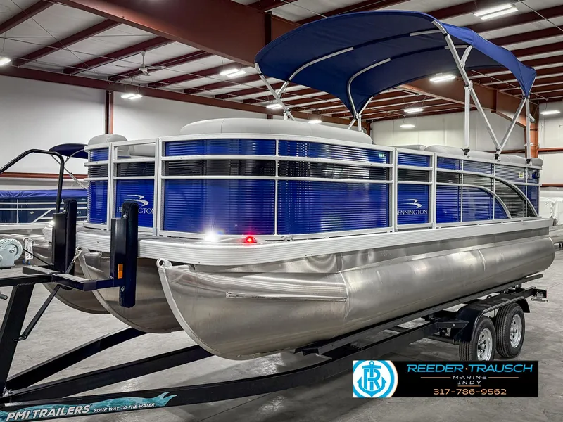 Slide: The Image of 2023 Bennington 208 SL pontoon boat with blue canopy in a showroom. - 3