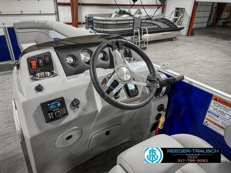 Slide: The Image of 2023 Bennington 208 SL boat dashboard with steering wheel and controls in showroom. - 30