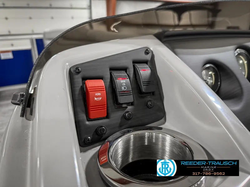 Slide: The Image of Control panel of 2023 Bennington 208 SL boat with switches and cup holder. - 33