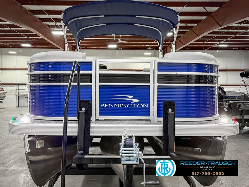 Slide: The Image of 2023 Bennington 208 SL pontoon boat in showroom, blue exterior, front view. - 5
