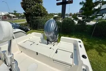 Slide: The Image of 2025 Bulls Bay 2200 boat with outboard motor, parked outdoors on grass. - 11