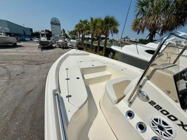 Slide: The Image of 2025 Bulls Bay 2200 boat at a dealership, surrounded by palm trees and other boats. - 8