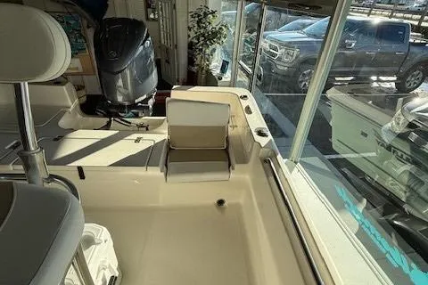 Slide: The Image of 2025 Bulls Bay 2200 boat interior with seating and motor, displayed in showroom. - 9